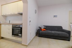 salon z kanapą i pomarańczową poduszką w obiekcie Apartment Rocky I w mieście Zadar