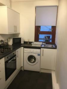 a kitchen with a washing machine and a sink at situated at the heart of fort william in Fort William