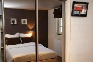 um quarto com uma cama e uma televisão na parede em Le Rouet em La Gleize