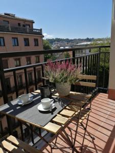 a table with cups and saucers on a balcony at Belle Egia - Free Parking in San Sebastián