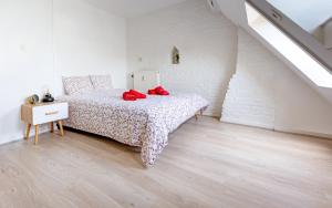 sypialnia z łóżkiem z czerwonymi poduszkami w obiekcie Les Cerisiers - Appartement de Standing au Centre de Namur w mieście Namur