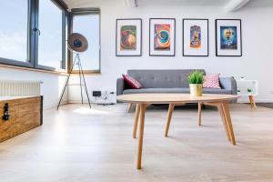 a living room with a couch and a table at Les Cerisiers - Appartement de Standing au Centre de Namur in Namur