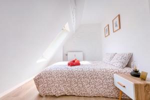 un dormitorio con una cama con un animal de peluche rojo en Les Cerisiers - Appartement de Standing au Centre de Namur, en Namur