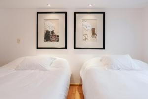 2 camas en una habitación con 3 cuadros en la pared en Beautiful apartment Ahuehuetes, en Ciudad de México