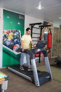 um homem em pé em uma esteira em uma academia em Pousada Suiça Mineira Centro em Monte Verde mais 198 fotografias