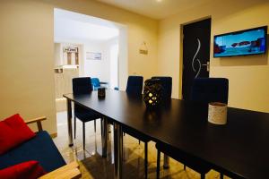 a dining room with a black table and chairs at Byzanthin Hostel in Bucharest