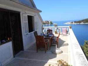 a balcony with a table and chairs and the water at Villa Maria in Lastovo
