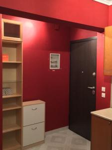 une chambre rouge avec une porte noire et un mur rouge dans l'établissement Aleka's House, à Thessalonique