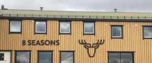 un bâtiment avec un cerf peint sur son côté dans l'établissement 8 SEASONS, à Varangerbotn