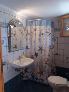 un bagno con lavandino e tenda da doccia di Avra Apartments a Leonidion (Leonidio)