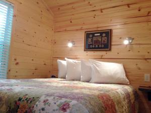 a bedroom with a bed in a wooden wall at Round Top Loft Cottage 2 in Gettysburg