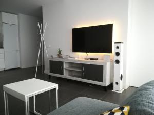 sala de estar con TV de pantalla plana y sofá en Marta & Lorenzo Apartment. Fuerteventura, en La Oliva