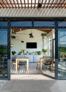 an outdoor patio with tables and chairs and a television at Langre Beach Surf Lodge in Galizano