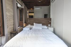 1 dormitorio con 1 cama grande y cabecero de madera en Sol y Luna de Triana, en Sevilla