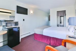 um quarto de hotel com uma cama grande e uma mesa em The Saco Motel em Saco