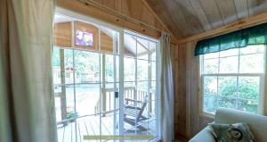 a room with a large window with a view of a porch at Round Top Premiere Cottage 6 in Gettysburg