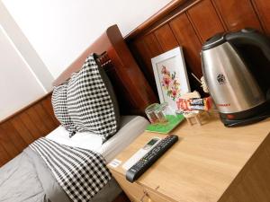 a bedroom with a bed and a desk with a coffee machine at VIỆT Hostel in Hue