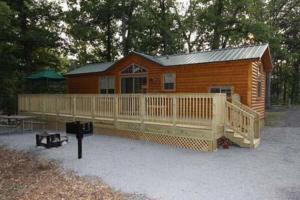 a large wooden cabin with a deck and a porch at Round Top Two-Bedroom Cottage 8 in Gettysburg