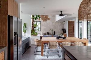 a kitchen and dining room with a wooden table and chairs at Villa Nonnavana - 12-minute walk to Batu Bolong Beach in Canggu