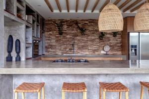 a kitchen with a counter and two stools at Villa Nonnavana - 12-minute walk to Batu Bolong Beach in Canggu +25 photos