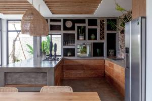 a kitchen with a counter and a refrigerator at Villa Nonnavana - 12-minute walk to Batu Bolong Beach in Canggu