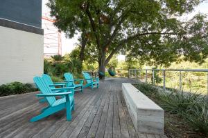 a row of wooden benches sitting on top of a lawn at Sonder at La Villita in San Antonio