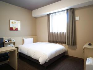 Hotel Route Inn Ofunato في Ōfunato: غرفه فندقيه بسرير ونافذه