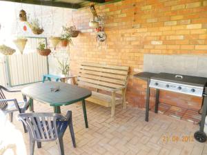 a patio with a bench and a table and a stove at Champion Bay Apartments in Geraldton