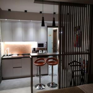 a kitchen with two bar stools and a counter at ACCOMMODO192 in Dnipro