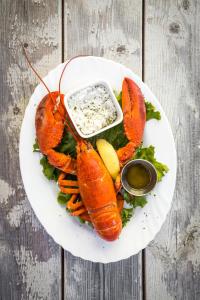 a plate of lobster with a side of dip at Auberge la Salicorne et Escapades - Adventure Resort in Grande-Entrée