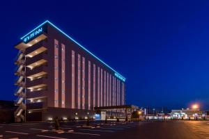 un hôtel avec un bâtiment éclairé la nuit dans l'établissement Hotel Route-inn Utsunomiya Yuinomori -Lightline Yuinomori Nishi-, à Utsunomiya