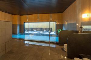 a bathroom with a swimming pool in a room at Hotel Route-inn Utsunomiya Yuinomori -Lightline Yuinomori Nishi- in Utsunomiya