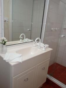 ein Badezimmer mit einem weißen Waschbecken und einem Spiegel in der Unterkunft Lake Central Cairns in Cairns
