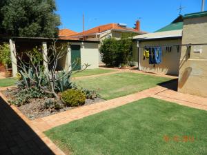 a yard with green grass and a house at Champion Bay Apartments in Geraldton