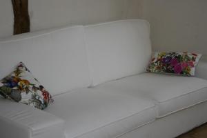 Un sofá blanco con dos almohadas. en Fita Hotel Rural, en Sequeros