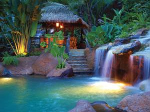 The Springs Resort & Spa at Arenal في فورتونا: شلال في وسط مسبح مع شلال ماء