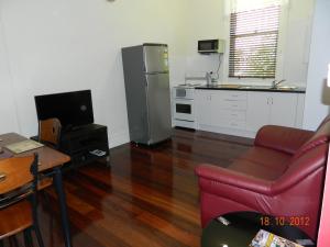 a living room with a red couch and a kitchen at Champion Bay Apartments in Geraldton