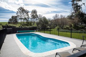 una piscina in un cortile con una recinzione di Maple Ridge Cottages a Dumbalk