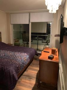 Dormitorio con cama, escritorio y TV en Departamento Nuevo con vista al mar, amoblado, en Concón