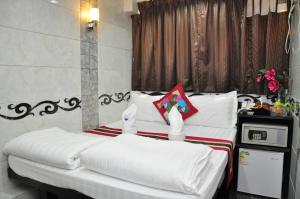 1 dormitorio con 2 camas con sábanas blancas en Pearl Premium Guest House(10/F), en Hong Kong