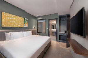 a bedroom with a large bed and a flat screen tv at Summit Galleria Cebu in Cebu City