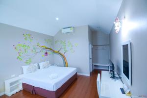 een slaapkamer met een muurschildering van bomen aan de muur bij Color Ville Hotel SHA Certified in Sakon Nakhon +45 foto's