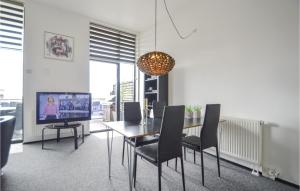 a dining room with a table and chairs and a television at 1 Bedroom Awesome Apartment In Rm in Havneby