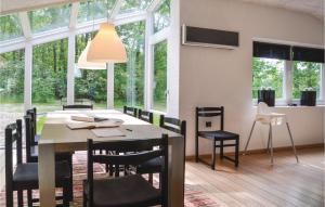 comedor con mesa, sillas y ventanas en Gorgeous Home In Hejnsvig With Kitchen, en Hejnsvig