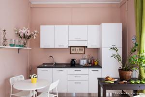 a kitchen with white cabinets and a small table at B&B St. Peter's Suites in Rome