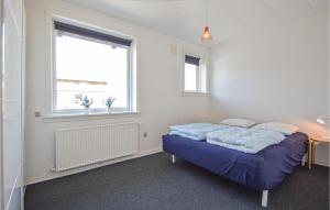 a bedroom with a blue bed and a window at Holiday Home Vesterende Bredebro Ix in Ballum +26 photos