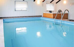BjerregårdにあるGorgeous Home In Hvide Sande With Indoor Swimming Poolの- 青い大型スイミングプール(洗面台付きのバスルーム内)