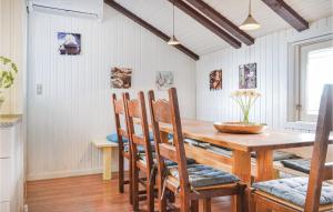 Un comedor con mesa y sillas de madera. en Awesome Home In Hvide Sande With Sauna, en Bjerregård