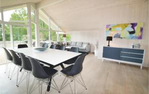 a dining room with a white table and chairs at Nice Home In Rdby With Wifi in Kramnitse