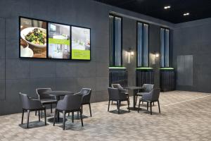 a room with tables and chairs and a tv on the wall at Hotel Ease Mong Kok in Hong Kong